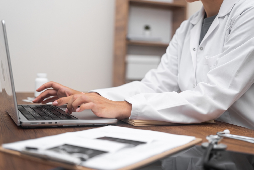 Close,Up,Doctor,Hands,Using,Laptop,,Video,Consultations,,Illustrating,The